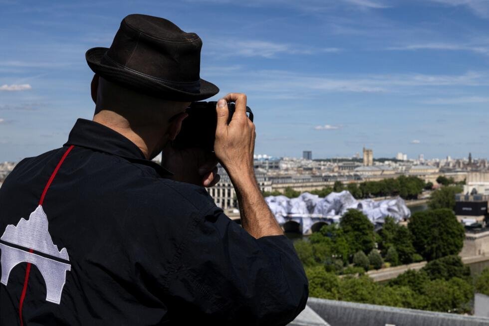L'artiste français JR photographie sa dernière œuvre, la "Caverne" installée sur le Pont-Neuf à Paris, le 1er juin 2026.